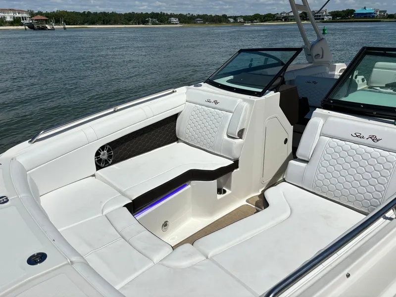 Slide: The Image of 2023 Sea Ray SDX 270 Outboard boat interior with white seating and waterfront view. - 10