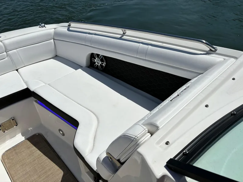 Slide: The Image of 2023 Sea Ray SDX 270 Outboard boat with white cushioned seating and water backdrop. - 12