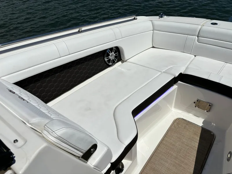 Slide: The Image of 2023 Sea Ray SDX 270 Outboard boat with white cushioned seating and water backdrop. - 13