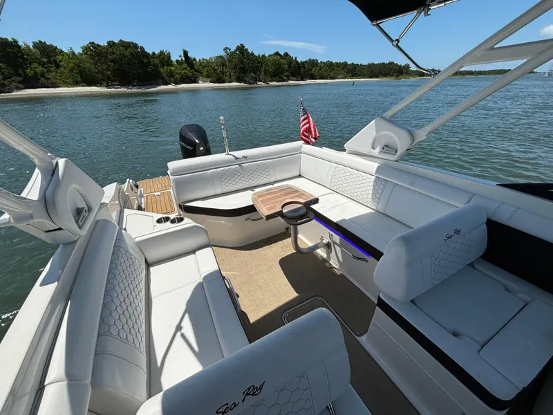 Slide: The Image of 2023 Sea Ray SDX 270 Outboard boat interior with white seating and scenic water view. - 20