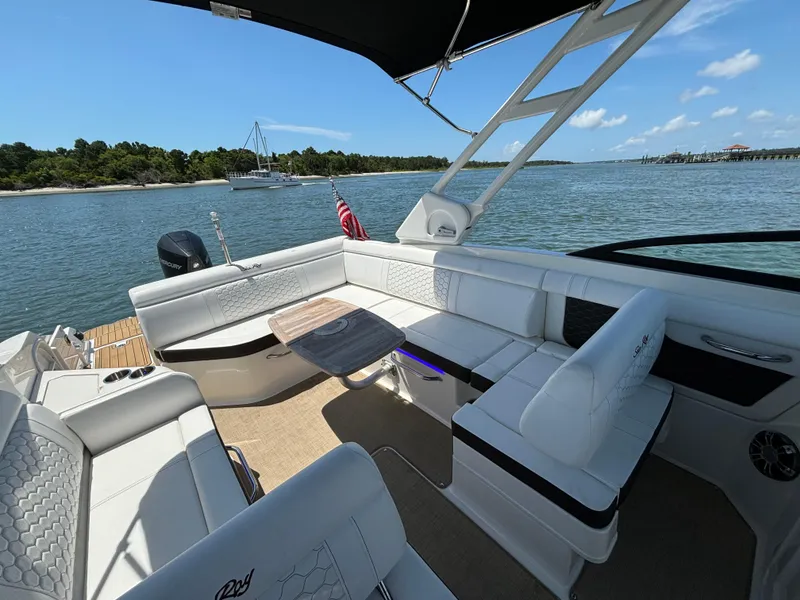 Slide: The Image of 2023 Sea Ray SDX 270 Outboard boat interior with white seating and scenic water view. - 28