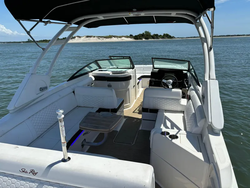 Slide: The Image of 2023 Sea Ray SDX 270 Outboard boat interior with seating and steering wheel on water. - 38