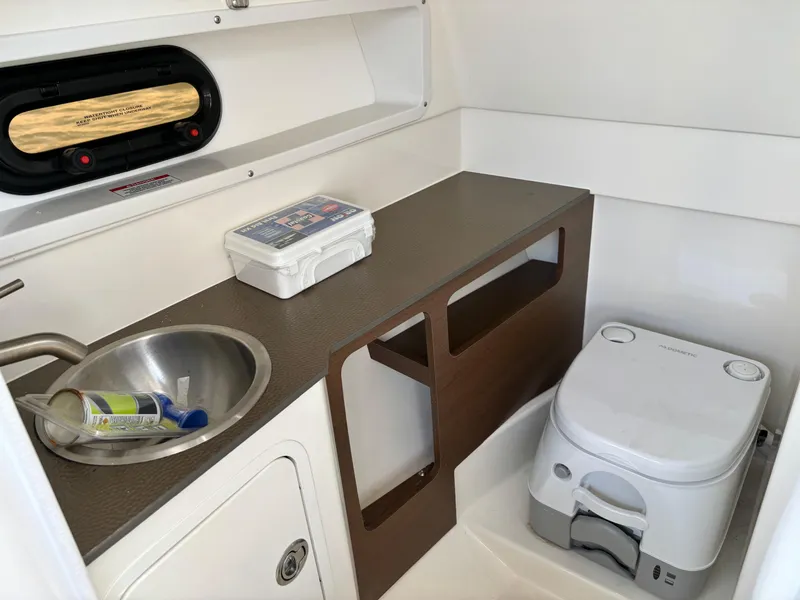 Slide: The Image of 2023 Sea Ray SDX 270 Outboard boat interior with sink and portable toilet. - 42