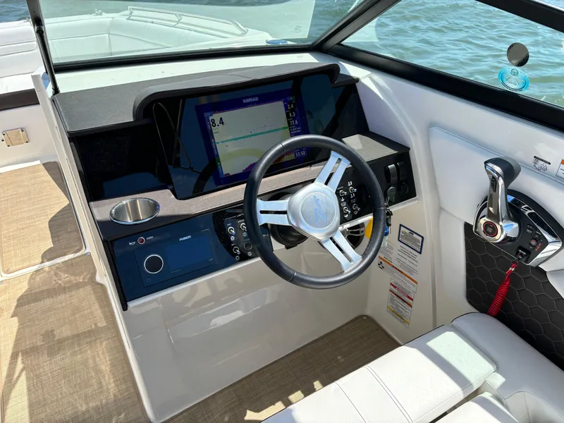 Slide: The Image of 2023 Sea Ray SDX 270 Outboard helm with steering wheel, control panel, and navigation display. - 43