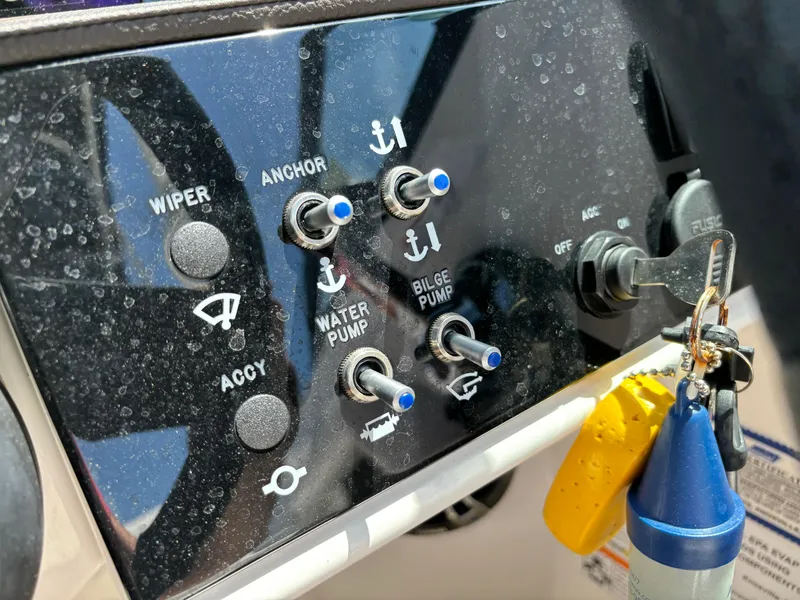 Slide: The Image of Control panel of 2023 Sea Ray SDX 270 Outboard boat with switches and ignition key. - 49