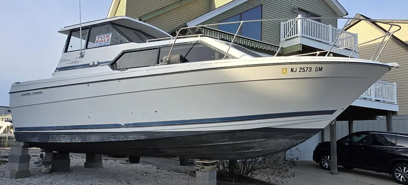 The Image of 2000 Bayliner 2859 Ciera Express boat on dry dock near residential area. - 0