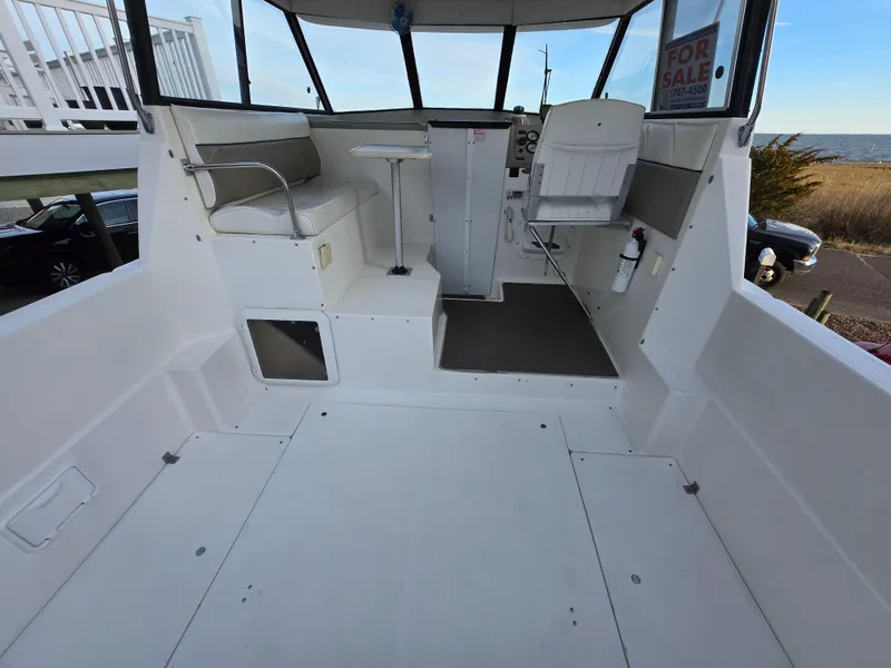 Slide: The Image of 2000 Bayliner 2859 Ciera Express boat interior with seating and helm, for sale sign visible. - 12