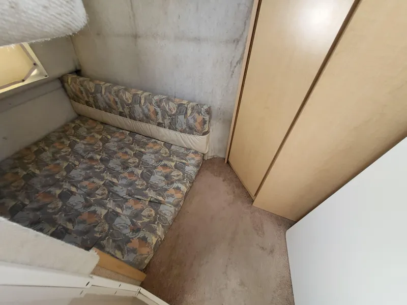 Slide: The Image of 2000 Bayliner 2859 Ciera Express cabin interior with patterned bedding and wooden cabinetry. - 17