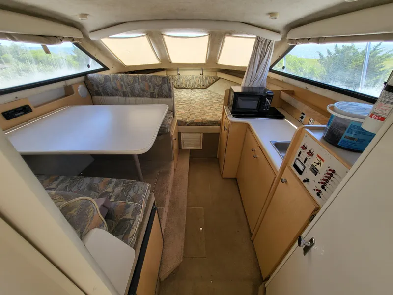 Slide: The Image of 2000 Bayliner 2859 Ciera Express cabin interior with dining area, kitchenette, and sleeping space. - 2