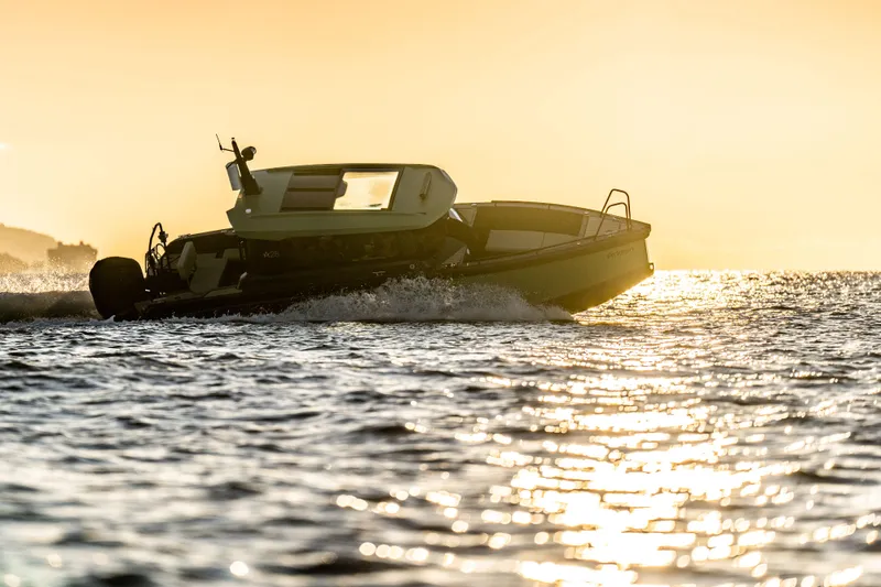 Slide: The Image of Arksen 28 boat cruising at sunset, 2025 model, on shimmering water. - 2
