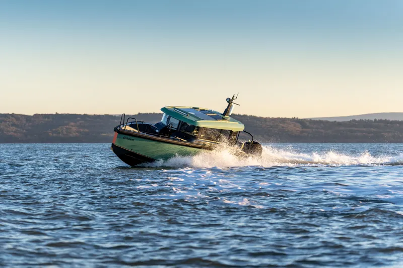 Slide: The Image of 2025 Arksen 28 boat cruising on open water at sunset. - 4