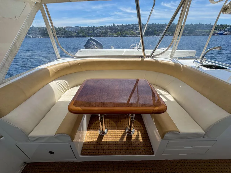 Slide: The Image of 2006 Ocean Alexander 58 Pilothouse yacht with cushioned seating and wooden table on deck. - 16