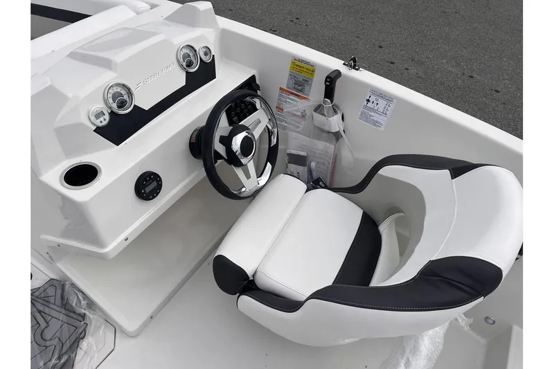 Slide: The Image of 2024 Starcraft SVX 171 OB boat cockpit with steering wheel and captain's chair. - 11
