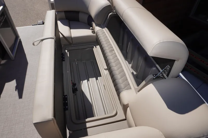 Slide: The Image of 2024 Sun Tracker Party Barge 20 DLX interior storage compartment with beige seating. - 4