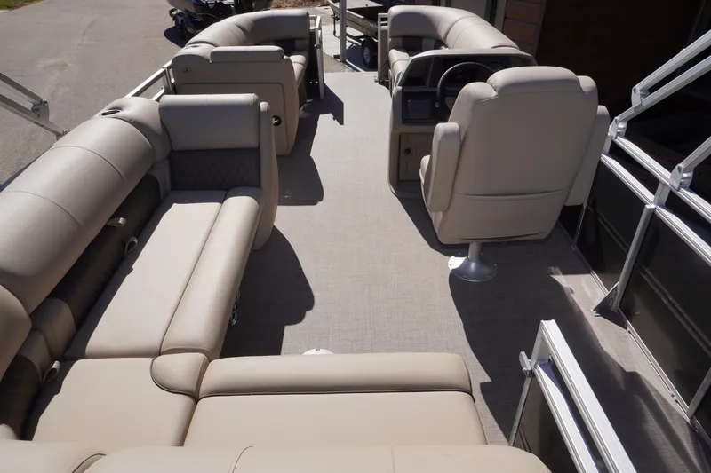 Slide: The Image of 2024 Sun Tracker Party Barge 20 DLX interior with beige seating and helm. - 5