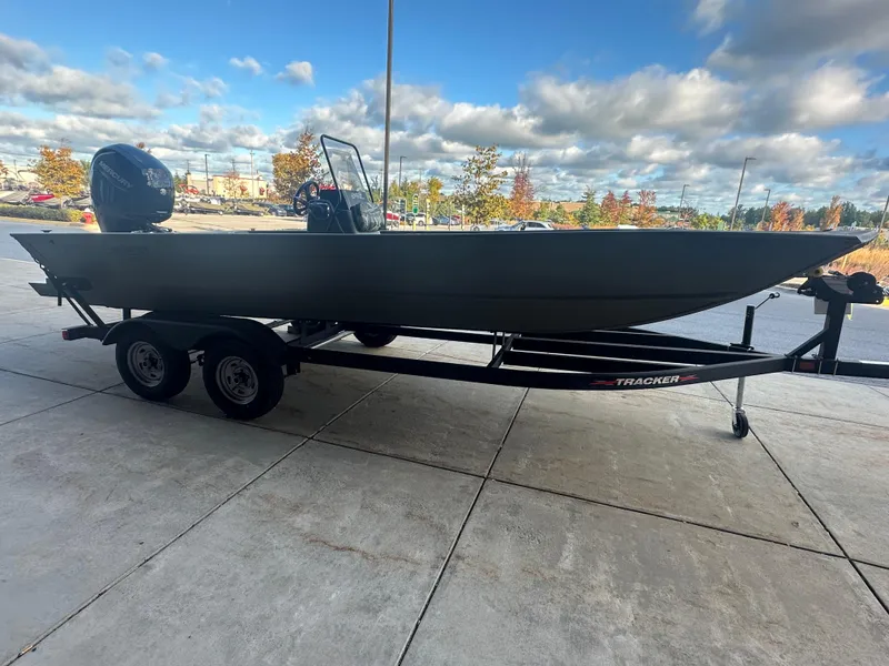 Slide: The Image of 2024 Tracker Grizzly 2072 CC boat on trailer, parked outdoors under cloudy sky. - 3