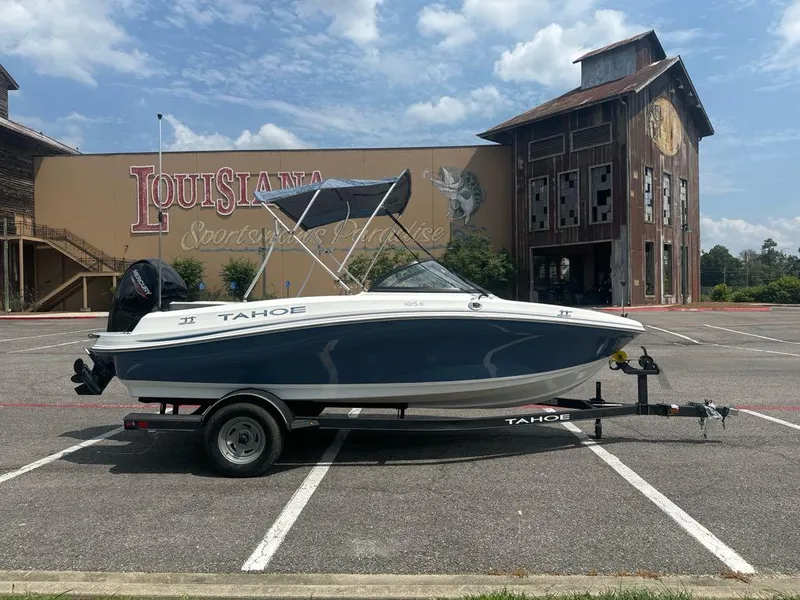 Slide: The Image of 2024 Tahoe 185 S boat on trailer in parking lot, Louisiana Sportsman’s Paradise backdrop. - 2