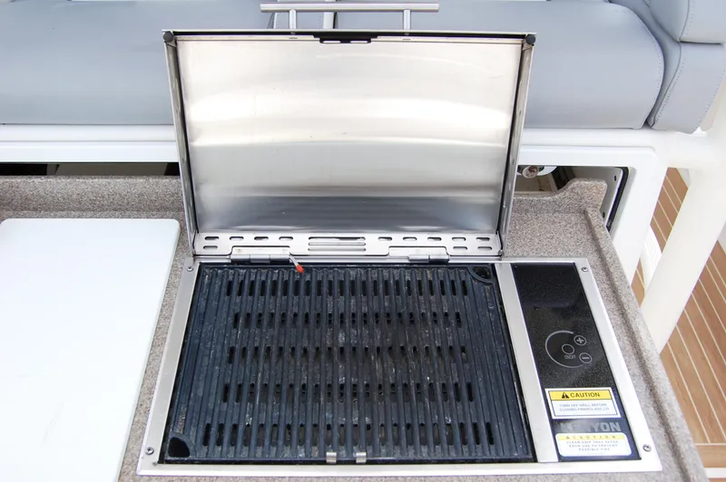 Slide: The Image of Built-in grill on 2019 Regulator 41 boat, open lid, stainless steel finish. - 19