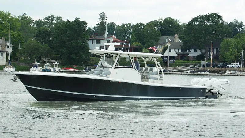 Slide: The Image of 2019 Regulator 41 boat cruising on a calm lake near a residential area. - 25