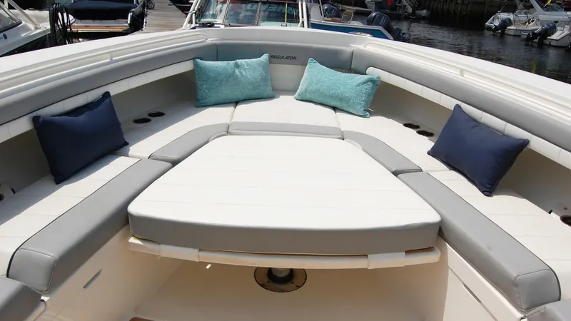 Slide: The Image of 2019 Regulator 41 boat with cushioned seating and colorful pillows. - 42