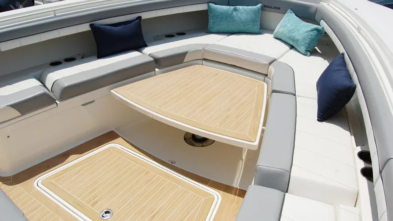 Slide: The Image of 2019 Regulator 41 boat interior with cushioned seating and wooden table. - 43