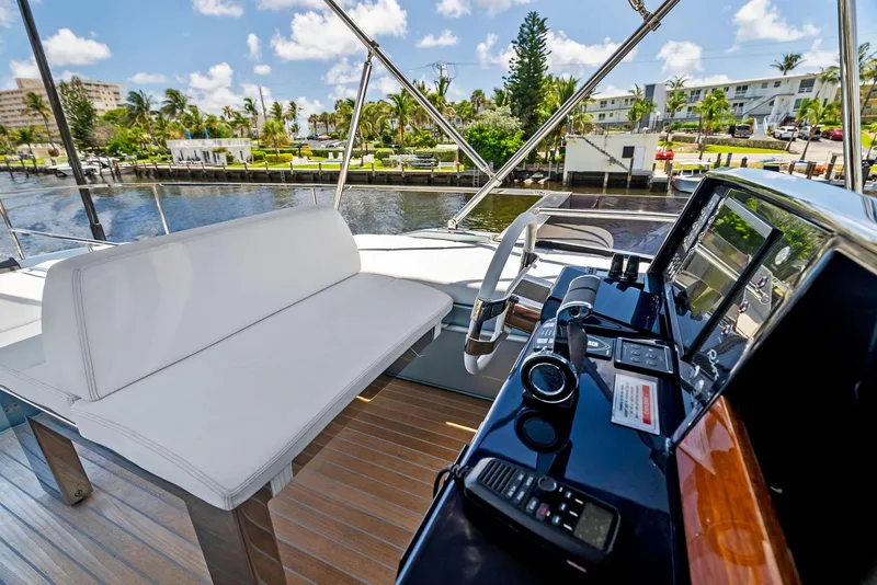 Slide: The Image of Cockpit view of 2020 Riva 66' Ribelle yacht with white seating and control panel. - 14