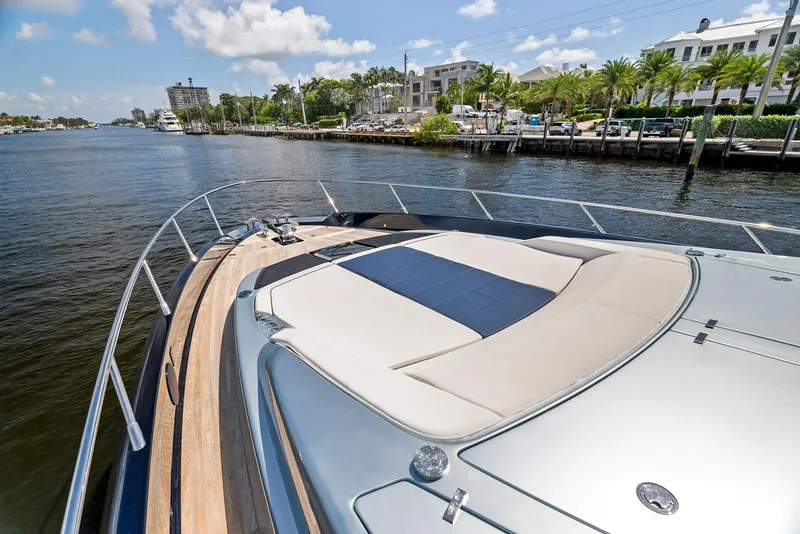 Slide: The Image of 2020 Riva 66' Ribelle yacht on a sunny day, docked near luxury waterfront homes. - 8