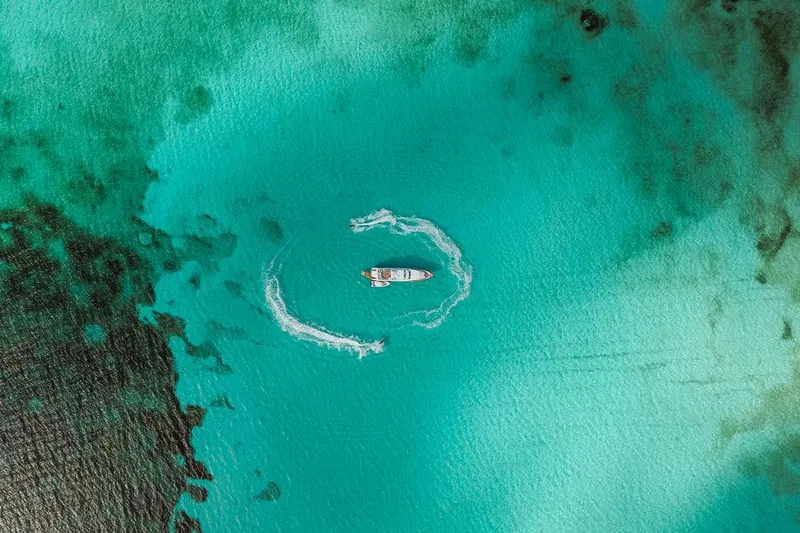 Slide: The Image of Aerial view of a 2006 Hargrave Motor Yacht cruising in clear turquoise waters. - 14