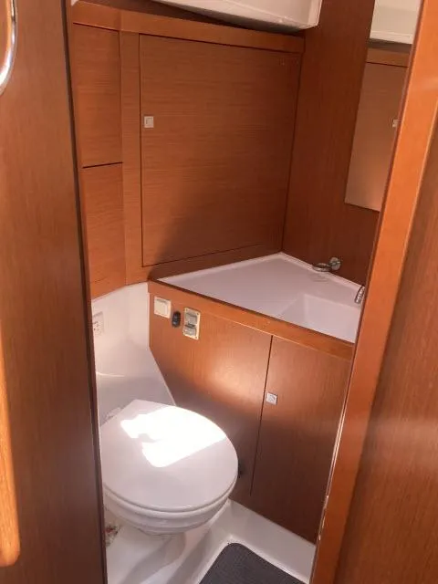 Slide: The Image of 2014 Beneteau Oceanis 45 bathroom with wooden cabinetry and white fixtures. - 14