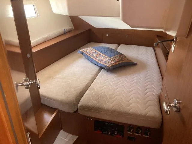 Slide: The Image of 2014 Beneteau Oceanis 45 cabin with twin beds and decorative pillow. - 16