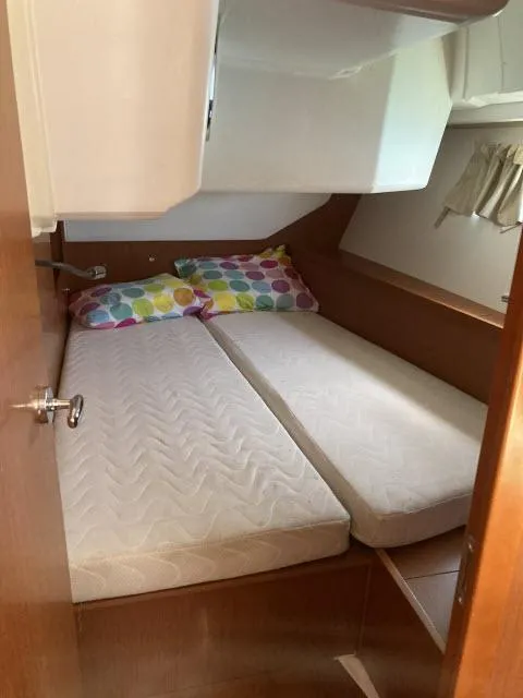 Slide: The Image of Beneteau Oceanis 45 2014 model cabin with twin beds and colorful pillows. - 19