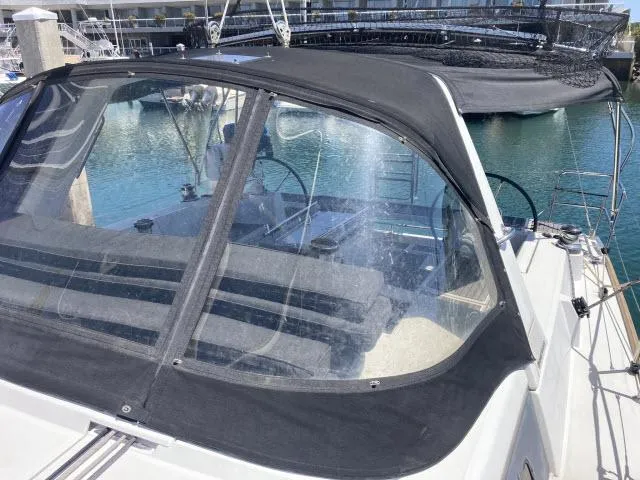 Slide: The Image of 2014 Beneteau Oceanis 45 sailboat cockpit with black canvas cover in marina. - 33