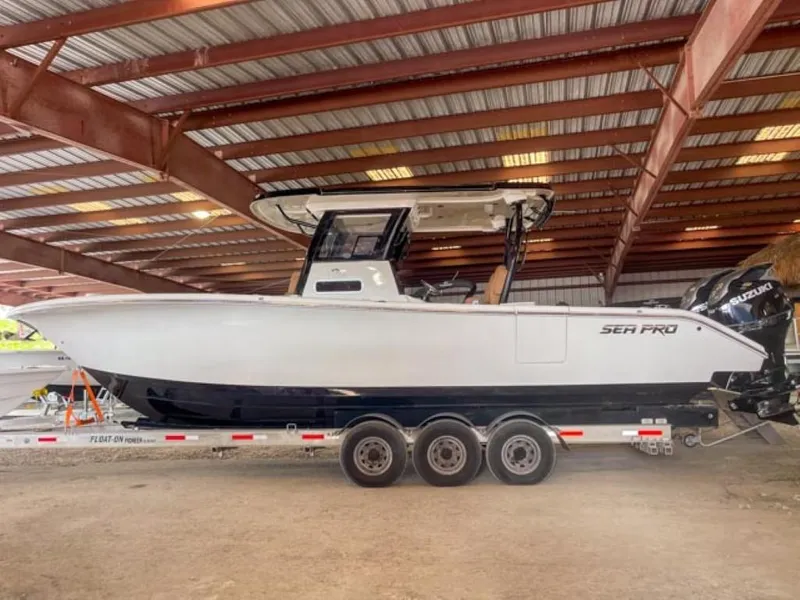 Slide: The Image of 2025 Sea Pro 322 Offshore boat on a trailer in a covered storage area. - 0