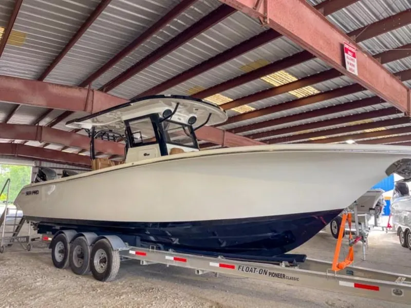 Slide: The Image of 2025 Sea Pro 322 Offshore boat on a trailer in a covered storage area. - 2