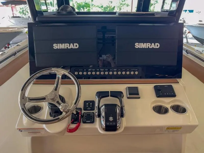 Slide: The Image of 2025 Sea Pro 322 Offshore boat helm with dual Simrad displays and Suzuki controls. - 4