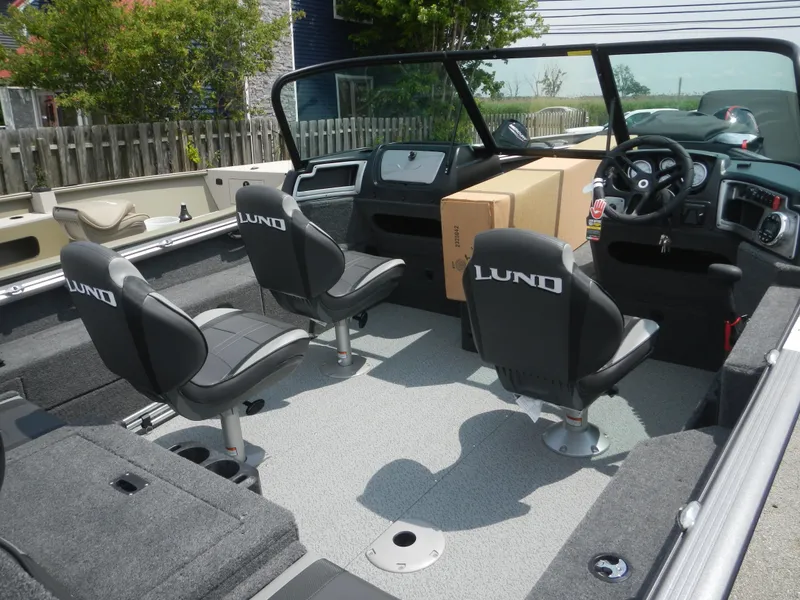 Slide: The Image of 2024 Lund 1775 Impact XS Sport boat interior with seating and dashboard. - 2