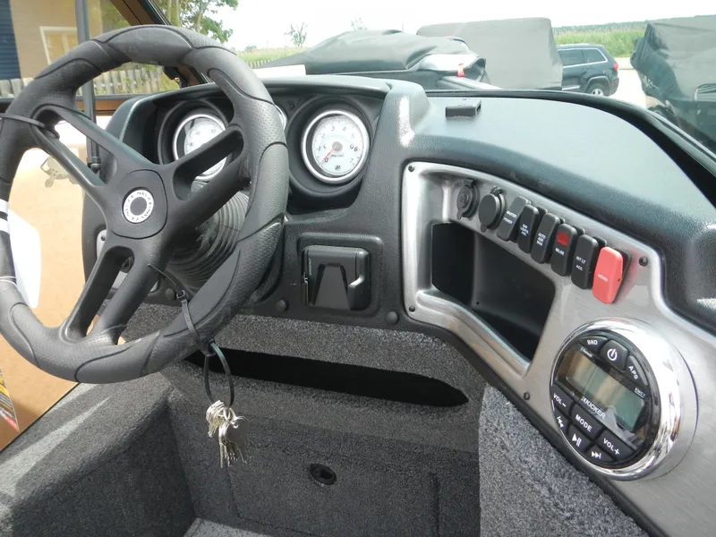 Slide: The Image of 2024 Lund 1775 Impact XS Sport boat dashboard with steering wheel and control panel. - 3
