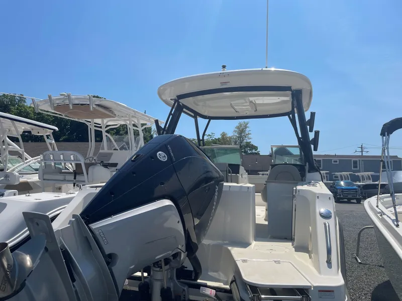 Slide: The Image of 2023 Boston Whaler 240 Vantage boat with outboard motor in a marina. - 3