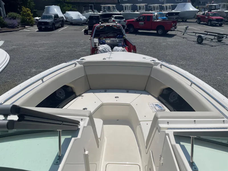 Slide: The Image of 2023 Boston Whaler 240 Vantage boat in a parking lot with trucks and trailers. - 9