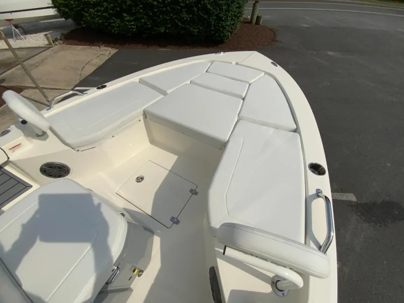 Slide: The Image of 2024 Pathfinder 2200 TRS boat with white cushioned seating and storage compartments. - 16