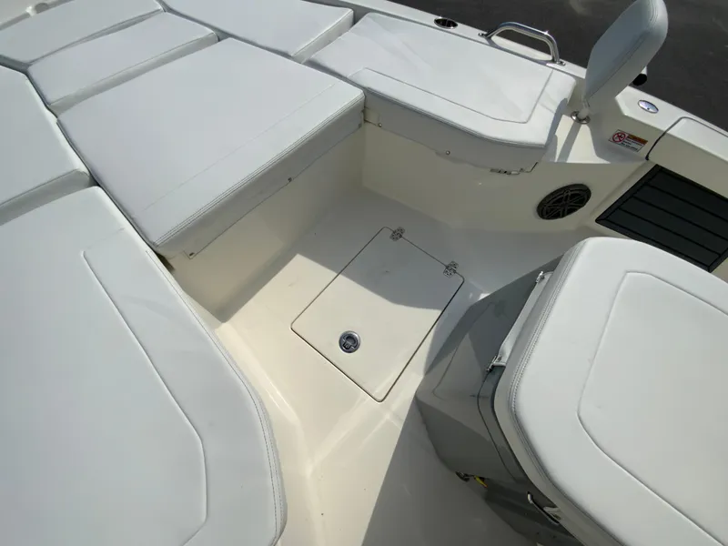 Slide: The Image of 2024 Pathfinder 2200 TRS boat interior with white cushioned seating and storage compartments. - 23