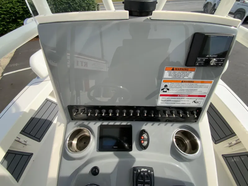 Slide: The Image of 2024 Pathfinder 2200 TRS boat dashboard with controls and cup holders. - 26