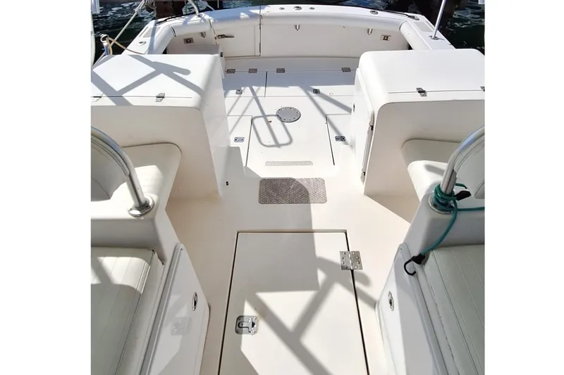 Slide: The Image of Spacious deck of a 2001 Topaz Express boat, featuring white seating and storage compartments. - 23