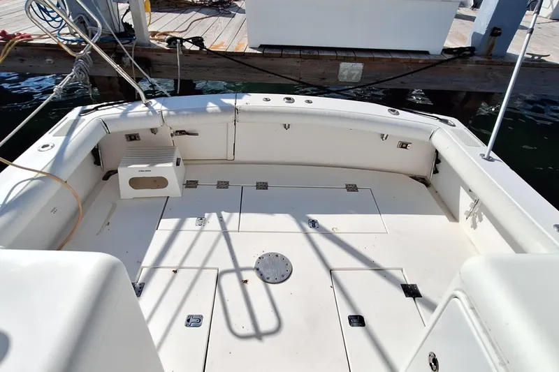 Slide: The Image of 2001 Topaz Express boat deck with storage compartments and seating, docked at a marina. - 24