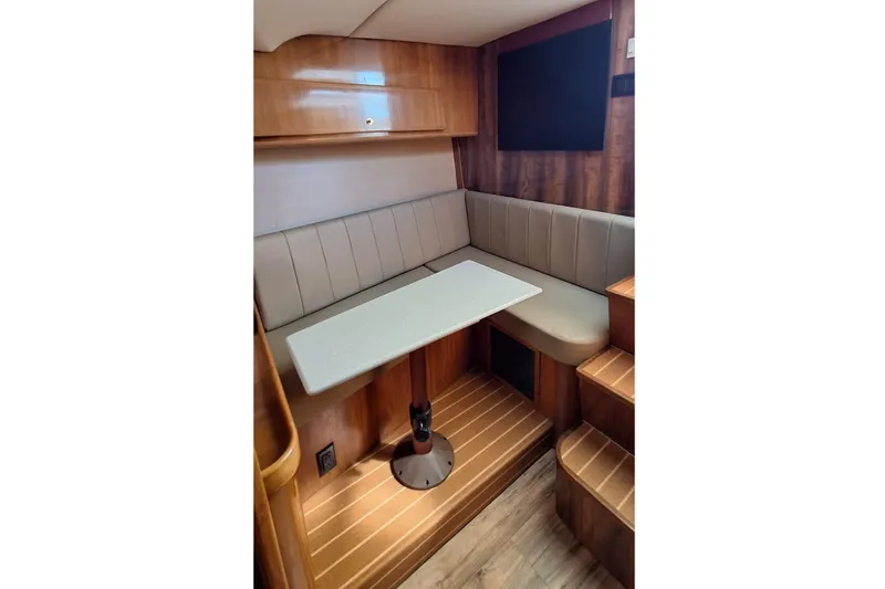 Slide: The Image of Cozy dining area in 2001 Topaz Express boat with wooden interior and cushioned seating. - 31