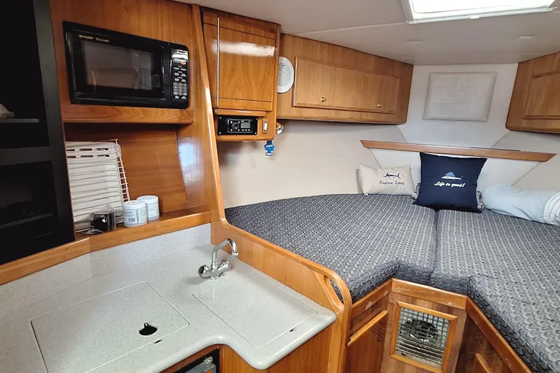 Slide: The Image of 2001 Topaz Express boat interior with kitchenette, microwave, and cozy sleeping area. - 33