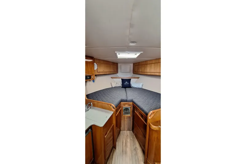 Slide: The Image of 2001 Topaz Express boat interior with cozy cabin, wooden cabinetry, and comfortable bedding. - 36
