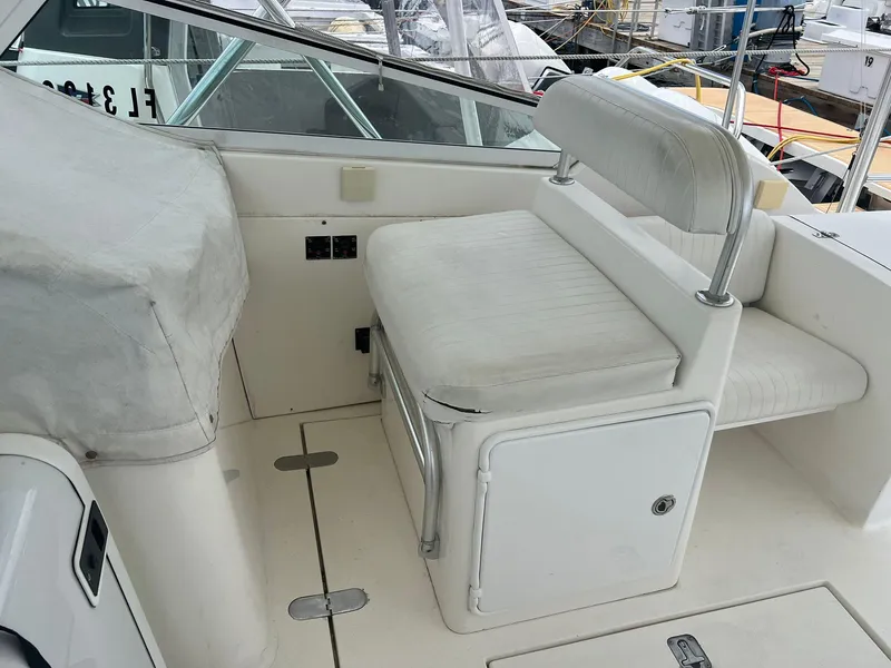 Slide: The Image of 2001 Topaz Express boat seating area with white cushioned seat and storage compartment. - 9