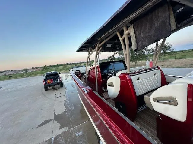 Slide: The Image of 2020 Nor-Tech 390 Sport Center Console boat with red exterior and white interior. - 4