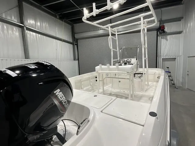 Slide: The Image of 2024 Bayliner T18BAY boat with Mercury outboard engine in a storage facility. - 5
